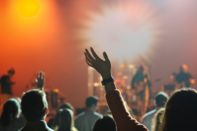 People with arms to the sky in worship People with arms to the sky in worship